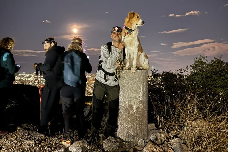 Συμμετέχων της Wanderlust με τον σκύλο του στη Ζαχαρίτσα του Ποικίλου Όρους κάτω από το φως της Πανσελήνου